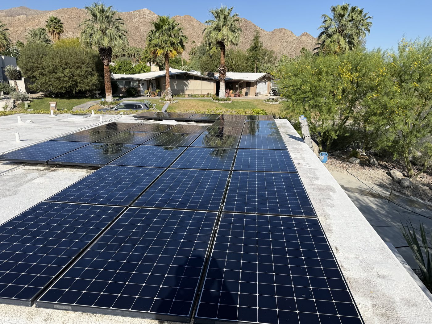 Clean, spotless solar panels reflecting the desert mountains after cleaning
